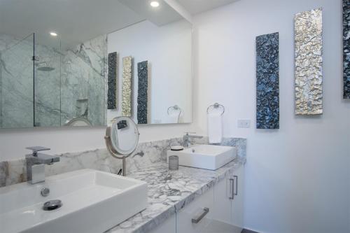 a white bathroom with two sinks and a mirror at Splash in The New Lazy River and Sleep In Luxury Encantame Towers Velero 2202 in Playa Encanto