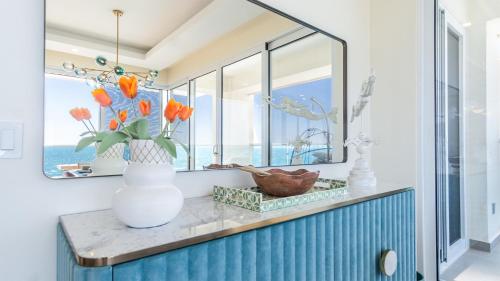 a vase of flowers on a counter in a room with windows at Amazing two bedroom beach front condo W1105 in Playa Encanto