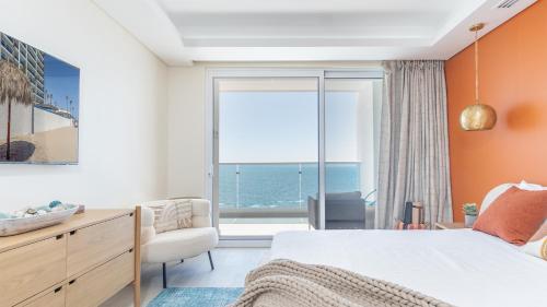a bedroom with a bed and a view of the ocean at Amazing two bedroom beach front condo W1105 in Playa Encanto