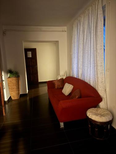 a living room with a red couch and a window at Bestapartman in Balatonboglár