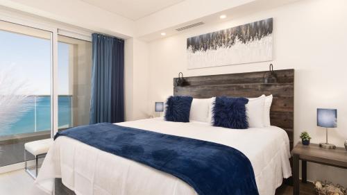 a bedroom with a large bed and a large window at Encantame Towers Viento 1103 in Playa Encanto