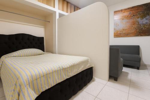 a bedroom with a bed and a chair in it at Acogedora suite privada en Urdesa Central, Guayaquil in Guayaquil