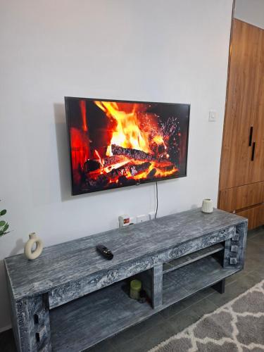 a tv on a wall with a fire underneath it at The Nest cozy stays in Kiambu