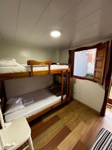 a room with two bunk beds and a window at Elizabetha Hostal in Salento
