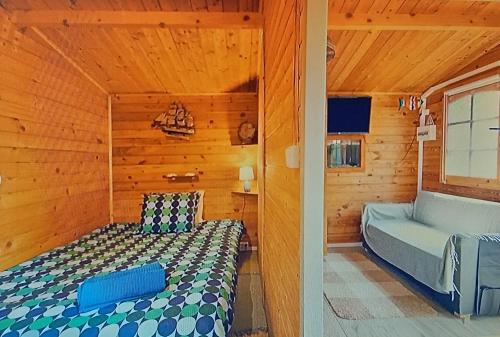 a bedroom with a bed in a wooden cabin at Dinocamp in Lourinhã