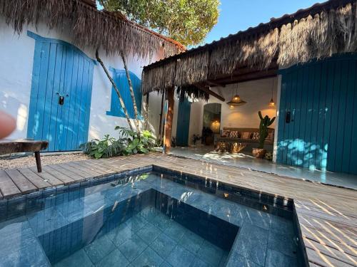 a house with a swimming pool in front of a house at Pousada Flor de Biriba Trancoso in Trancoso