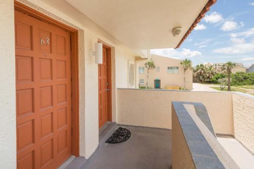 a red door on a building with a balcony at Pier Point South Oceanfront Townhouse Condo E-63 in Saint Augustine Beach
