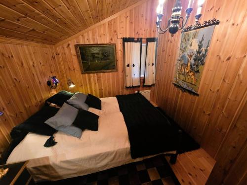 ein Schlafzimmer mit einem Bett in einem Holzzimmer in der Unterkunft Cozy Cabin Retreat in Trysil, Norway for Families in Mælem