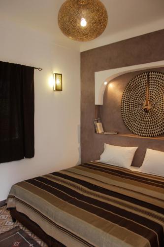 een slaapkamer met een groot bed met een plafond bij Riad Miliana in Marrakesh