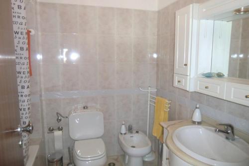 y baño con aseo blanco y lavamanos. en Apartamento Santa Cruz, en Santa Cruz