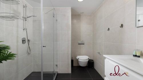 a bathroom with a shower and a toilet and a sink at Designer suite in Sea Side complex - By Edomlux in Eilat