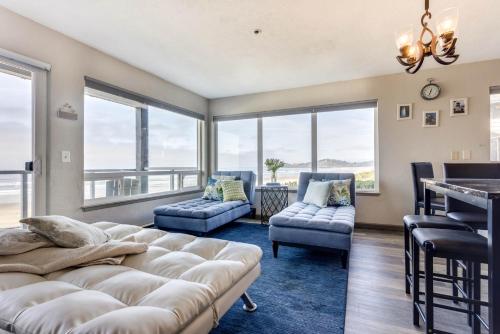 a living room with a couch and chairs and windows at Ocean Front Condo, View of Lighthouse, Nye Beach! Nye Beacon in Newport