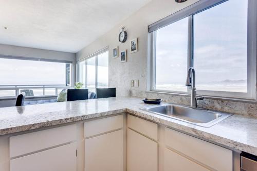 a kitchen with a sink and a large window at Ocean Front Condo, View of Lighthouse, Nye Beach! Nye Beacon in Newport