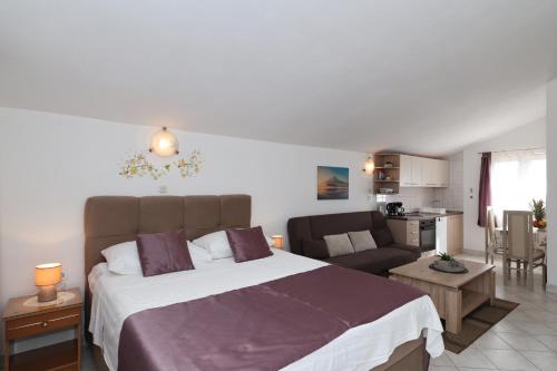 a bedroom with a large bed and a couch at Apartments Miljenka in Nin