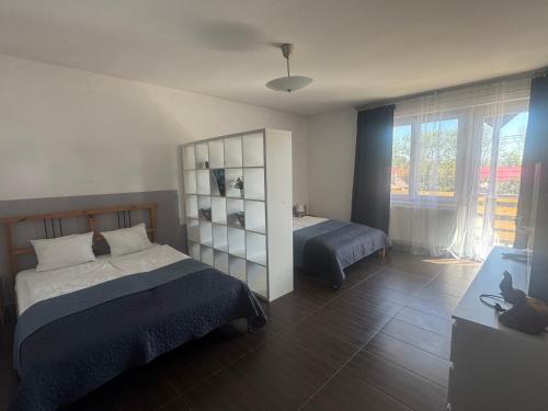 a bedroom with two beds and a large window at Bestapartman in Balatonboglár