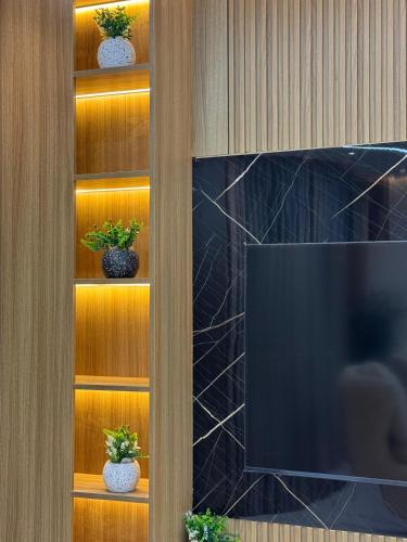 a entertainment center with a tv and some plants at Luxury appartment New Cairo in New cairo