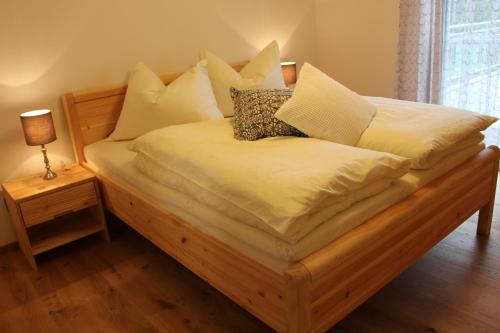 a bed with white sheets and pillows on it at Weingartenhaus in Leutschach