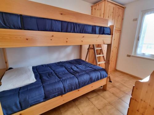 a bedroom with two bunk beds and a ladder at Villa Erica in Alba di Canazei