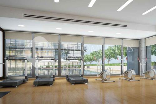 a gym with several chairs and a large window at Bloomfileds Cozy Stu in Park View in Abu Dhabi