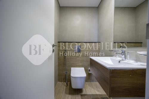 un bagno con un water bianco e un lavandino di Boomfields Iconic 2Br In The Gate Masdar a Abu Dhabi Intl