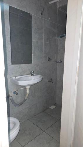 a bathroom with a sink and a mirror and a toilet at Serenity Brown Pad in Kiambu