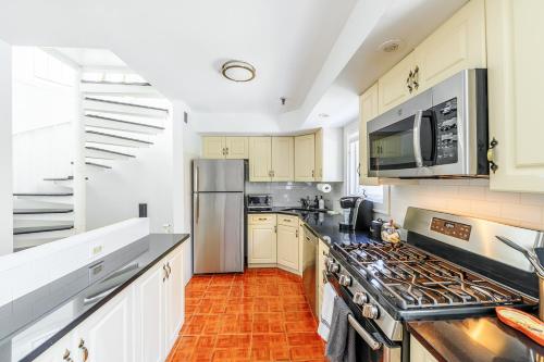 a kitchen with a stove and a refrigerator at Modern 3BR Townhouse with Private Rooftop & Parking Minutes to NYC in Hoboken