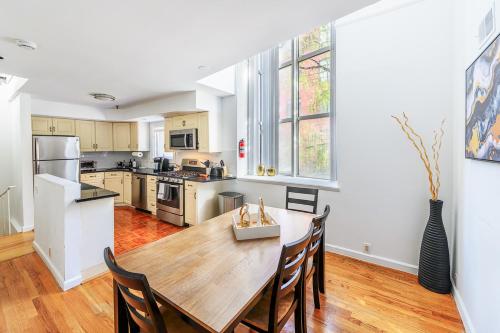 a kitchen with a wooden table and chairs at Modern 3BR Townhouse with Private Rooftop & Parking Minutes to NYC in Hoboken