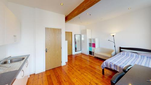 a bathroom with a bed and a sink in a room at Heart of Notts, Spacious Studio, Great City Views in Nottingham