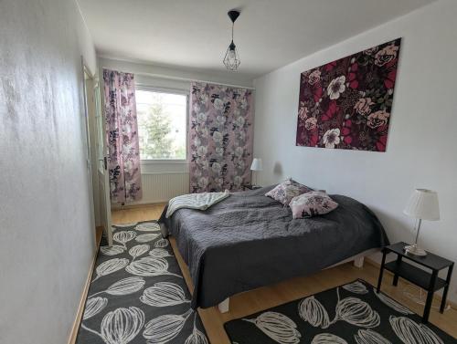 a bedroom with a bed and a window at Spacious two-room apartment by the lake in Rovaniemi