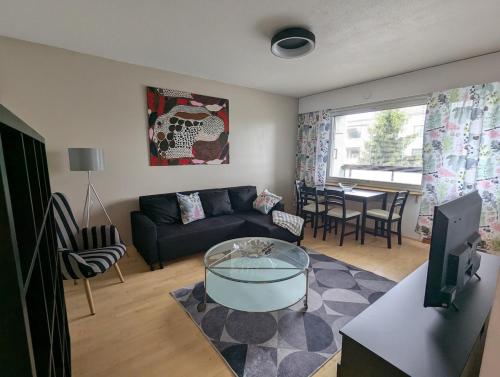 a living room with a couch and a table at Spacious two-room apartment by the lake in Rovaniemi