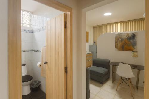 a bathroom with a table and a chair and a desk at Acogedora suite privada en Urdesa Central, Guayaquil in Guayaquil