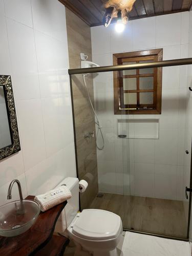 a bathroom with a shower and a toilet and a sink at Hospedaria Sol & Lua in São Bento do Sapucaí