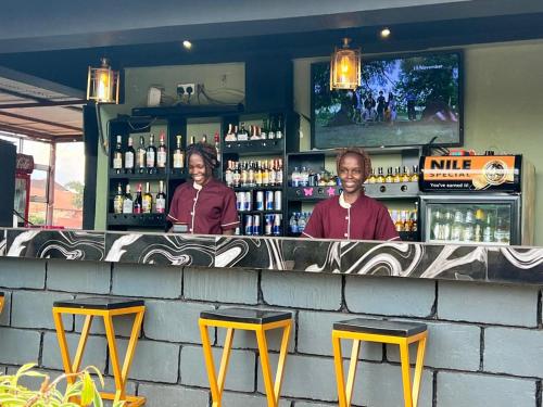 a man and a woman standing at a bar at Javelin Palace Hotel in Kampala