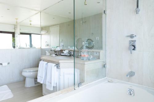 a bathroom with a tub and a sink and a toilet at Ébano by PB - Palacio Borghese in Oaxaca City