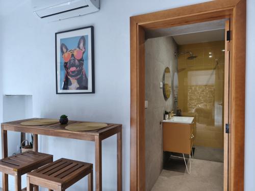 a bathroom with a table and a sink with a dog picture at Las Huertas del Abrilongo in La Codosera