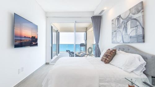 a bedroom with a bed and a view of the ocean at Encantame Towers Velero 901 in Playa Encanto