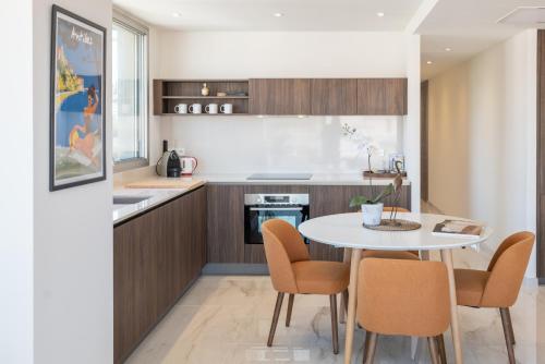 a kitchen with a table and chairs in a room at Sweett - Maison Blanche in Juan-les-Pins