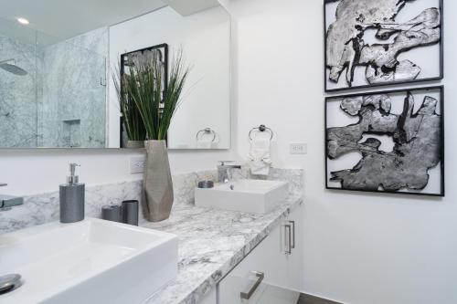 ein weißes Badezimmer mit zwei Waschbecken und einem Spiegel in der Unterkunft Amazing 2 bedroom Beach Front Condominium at Encantame C1102 in Playa Encanto