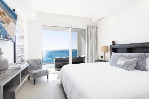 ein Schlafzimmer mit Bett, Schreibtisch und Fenster in der Unterkunft Amazing 2 bedroom Beach Front Condominium at Encantame C1102 in Playa Encanto