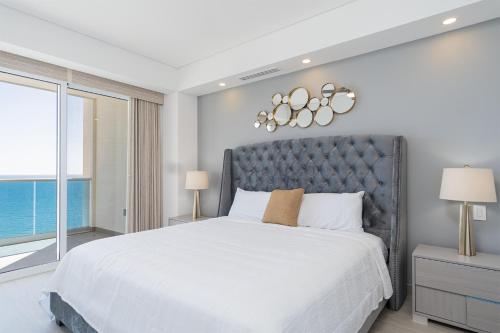 ein Schlafzimmer mit einem großen Bett und einem großen Fenster in der Unterkunft Splash in The New Lazy River and Sleep In Luxury Encantame Velero 1103 in Playa Encanto