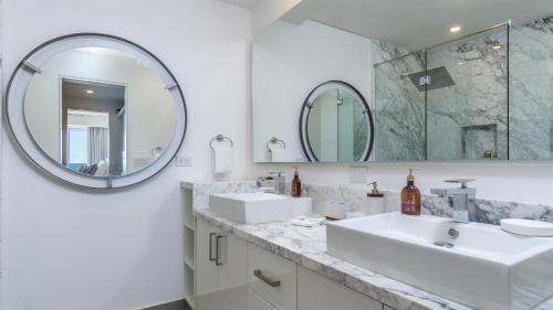 ein weißes Badezimmer mit zwei Waschbecken und einem Spiegel in der Unterkunft New and Amazing 3 bedroom Ground Floor Corner Beach Front Encantame C-101 in Playa Encanto