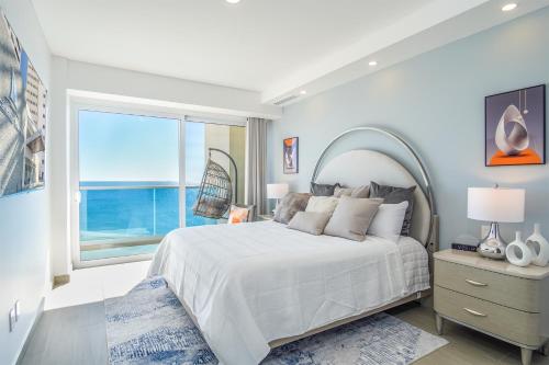 a bedroom with a large bed and a large window at Sublime 3 bedroom condo Encantame Towers Verano 801 in Playa Encanto