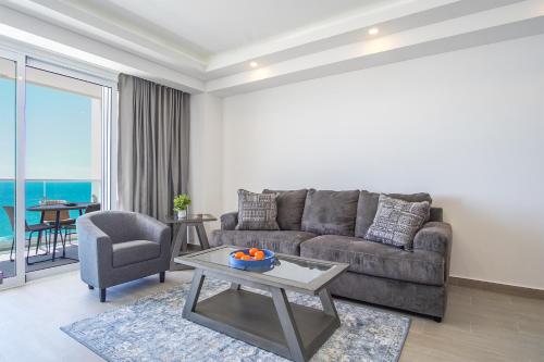 a living room with a couch and a table at Panoramic beach front condo Verano 1703 in Puerto Peñasco