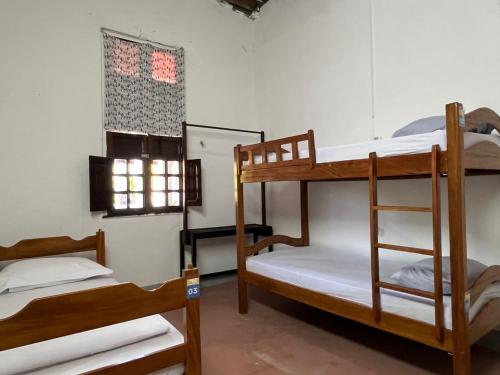 a room with three bunk beds and a window at Hostel Divino do Carmo in Olinda
