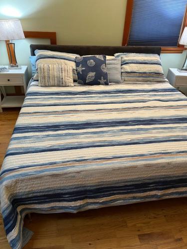 a large bed in a bedroom with a striped blanket at Art and Book Lovers in Eugene