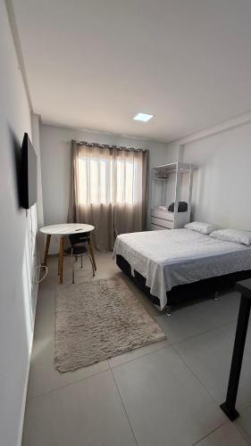 a bedroom with a bed and a table and a desk at West fit 720 in Mossoró