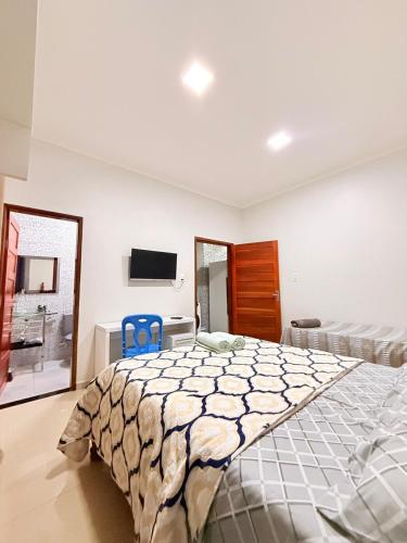 a bedroom with a large bed and two blue chairs at Nina lar in Boa Vista