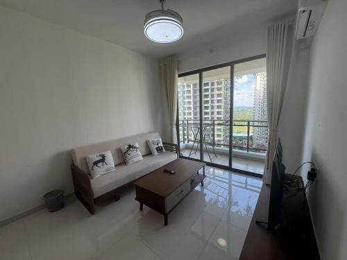 a living room with a couch and a large window at Forest City Homestay 森林民宿 in Gelang Patah