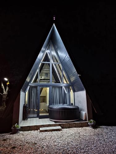 a small house with a large window and a black tub at Oaza mira, Brutusi near Bjelašnica in Trnovo