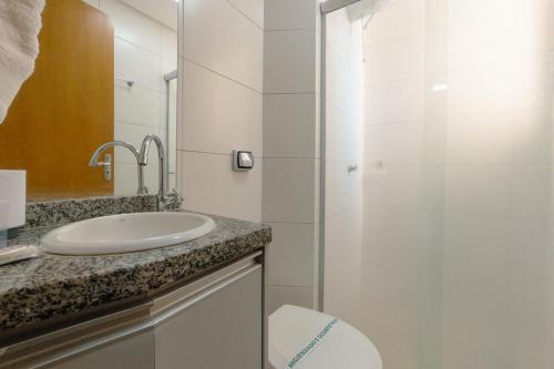 a bathroom with a sink and a glass shower at Aproveite este achado! - GC1108 in Maringá